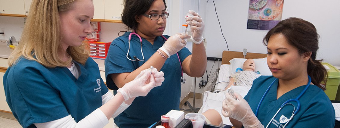 LPN students practice taking liquid from bottles using syringes