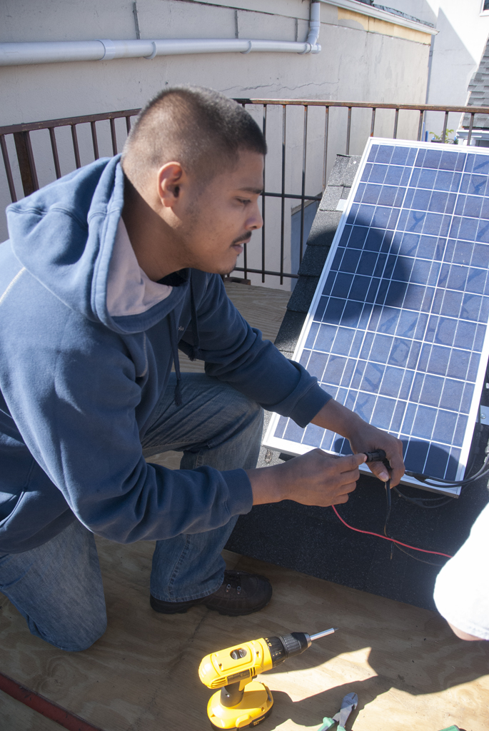 Construction training student practices setting up solar panel