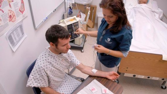 medical student practices taking blood on volunteer