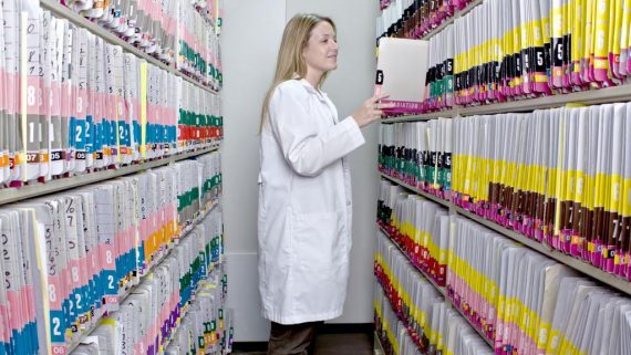 medical billing and coding student adds files in medical records room
