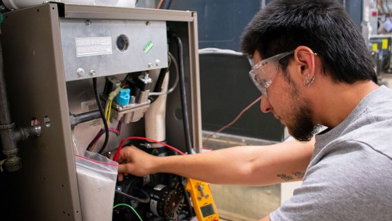 hvac student practices wiring air conditioning unit
